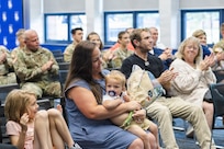 Family, friends, fellow Soldiers and colleagues applaud Illinois Army National Guard Lt. Col. Aaron A. Hepner after he presented flowers to his wife, Jennifer, during his promotion ceremony.