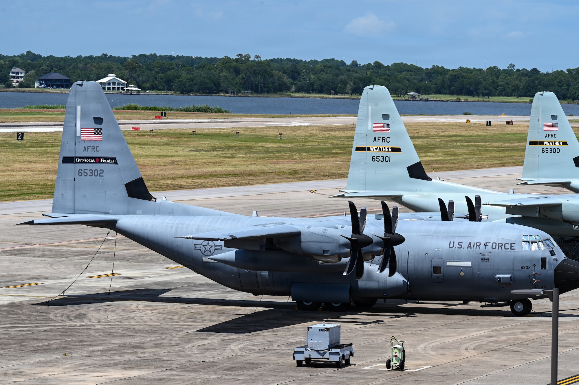 Three WC-130J Super Hercules aircraft wait on a flight line