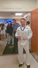 Naval Hospital Jacksonville Hospital Corpsman 3rd Class Konstantin Lukianeko poses with his certificate of U.S. citizenship following a ceremony at the Jacksonville U.S. Citizenship and Immigration Services office, July 21. Lukianeko joined the Navy four and half years ago to assist him in his citizenship journey and for financial stability after leaving Russia. (Courtesy photo)