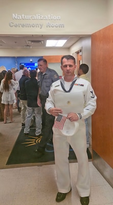 Naval Hospital Jacksonville Hospital Corpsman 3rd Class Konstantin Lukianeko poses with his certificate of U.S. citizenship following a ceremony at the Jacksonville U.S. Citizenship and Immigration Services office, July 21. Lukianeko joined the Navy four and half years ago to assist him in his citizenship journey and for financial stability after leaving Russia. (Courtesy photo)