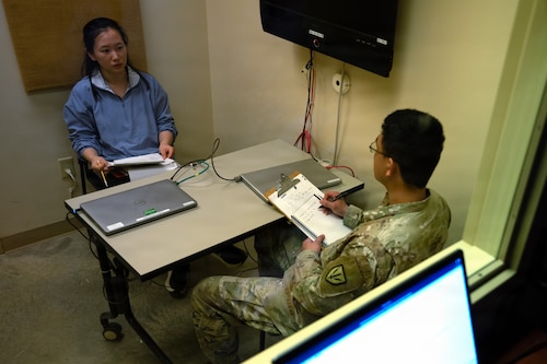 A U.S. Soldier takes notes while speaking to an Airman with the U.S. Air Force Language Enabled Airman Program in a foreign language during a simulated interrogation at Joint Base San Antonio-Camp Bullis, Texas, Feb. 26, 2026. The Airman played the role of a foreign civilian holding critical information, testing the Soldier’s translation and interview skills during exercise Cobra Engaged, hosted by Camp Bullis Foundry.