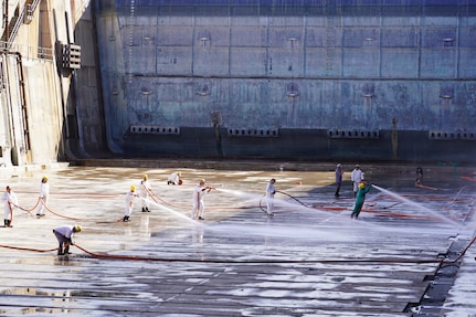 Workers with Pearl Harbor Naval Shipyard and Intermediate Maintenance Facility (PHNSY & IMF), perform a basin washdown of Dry Dock 2 immediately following dry dock dewatering at Joint Base Pearl Harbor-Hickam, July 7, 2026.