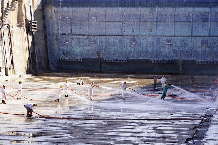Workers with Pearl Harbor Naval Shipyard and Intermediate Maintenance Facility (PHNSY & IMF), perform a basin washdown of Dry Dock 2 immediately following dry dock dewatering at Joint Base Pearl Harbor-Hickam, July 7, 2026.