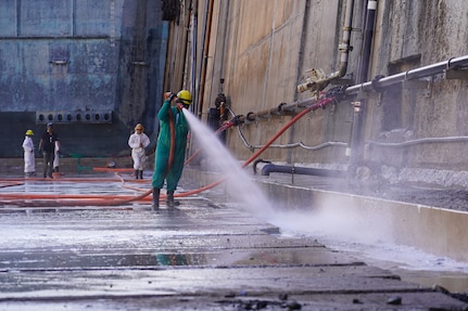 Dayton Remigio, Maintenance worker leader with Pearl Harbor Naval Shipyard and Intermediate Maintenance Facility (PHNSY & IMF), performs a high-pressure basin washdown of Dry Dock 2 immediately following dry dock dewatering at Joint Base Pearl Harbor-Hickam, July 7, 2026.