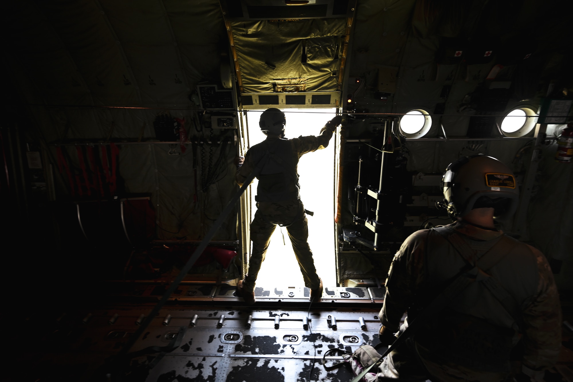 A person stands in the doorway of a plane
