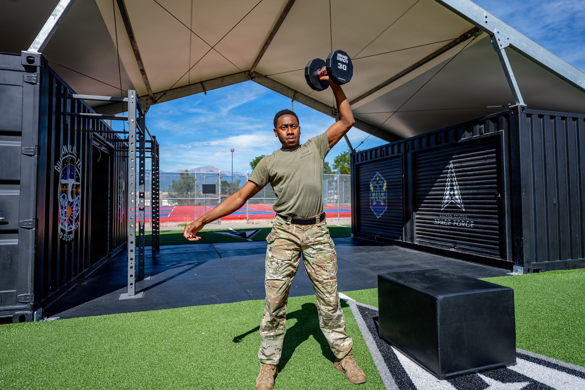 U.S. Air Force Tech. Sgt. John Foster, 21st Security Forces Squadron response force member, performs a dumbbell box step-over