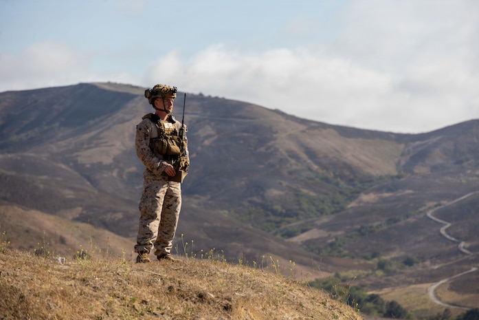 U.S. Marine Corps Sgt. Christian Nava, a joint terminal attack controller instructor with Fire Support Battalion, 11th Marine Regiment, 1st Marine Division, observes downrange during a Tactical Air Control Party exercise at Marine Corps Base Camp Pendleton, California, Aug. 13, 2026. The exercise was the culminating event for the TACP School, which trains forward air controllers and joint terminal attack controllers to better coordinate air support assets and calls for fire.  Nava is a native of California. (U.S. Marine Corps photo by Cpl. Stella Tedesco)
