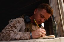 U.S. Marine Corps Sgt. Christian Nava, a joint terminal attack controller instructor with Fire Support Battalion, 11th Marine Regiment, 1st Marine Division, writes evaluations of his students during a Tactical Air Control Party exercise at Marine Corps Base Camp Pendleton, California, Aug. 13, 2026. The exercise was the culminating event for the TACP School, which trains forward air controllers and joint terminal attack controllers to better coordinate air support assets and calls for fire.  Nava is a native of California. (U.S. Marine Corps photo by Cpl. Stella Tedesco)