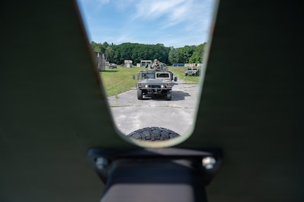 A U.S. Air National Guard tactical vehicle travels along a wooded route during convoy training at Patriot Forge II.