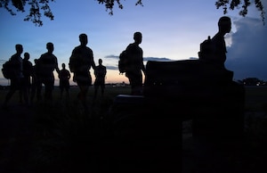 U.S. Airmen march past a memorial bench.