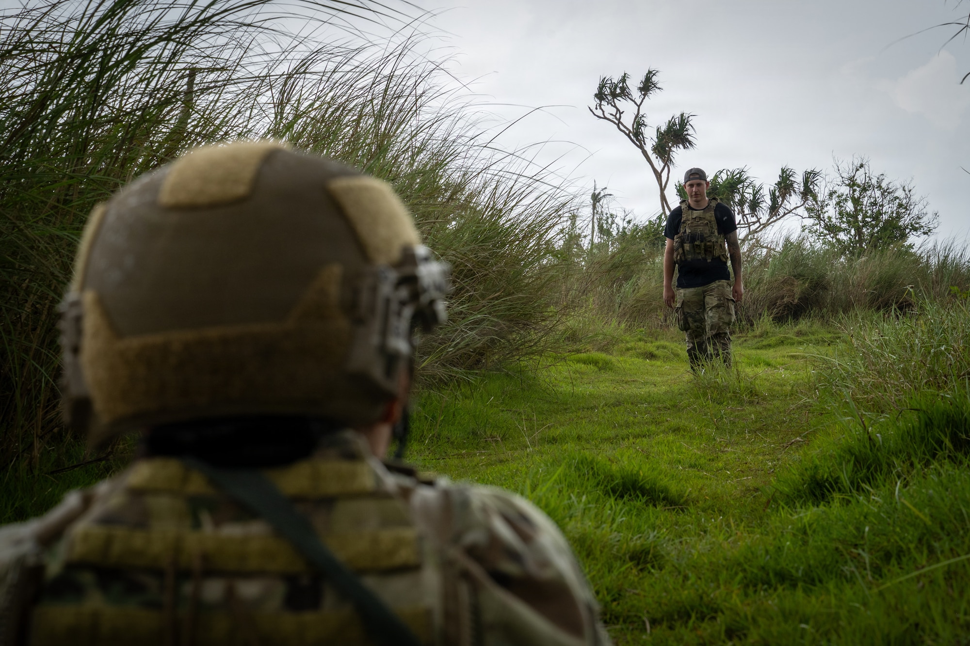 U.S. Air Force Senior Airman Preston Saunders, 21st Combat Air Base Squadron security forces response force member, observes an Airman acting as an opposing forces member during Pacific Defender Sustainment Training 2026 at Northwest Field, Guam, August 7, 2026. 21st CABS Airmen simulated both the response force and OPFOR members to effectively provide realistic training scenarios for Airmen participating in PDST. (U.S. Air Force photo by Senior Airman Adrien Tran)