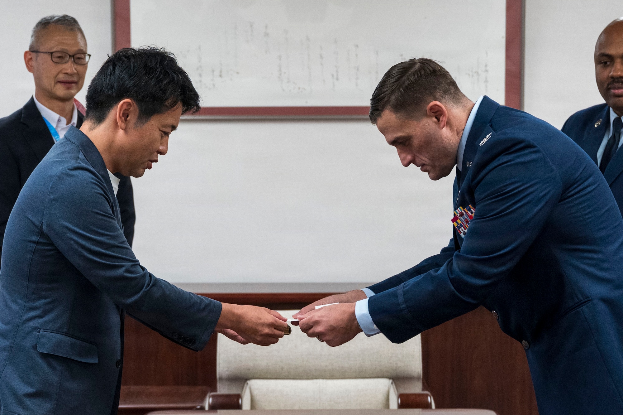 Aomori Prefecture Gov. Sōichirō Miyashita, left, and U.S. Air Force Col. Oliver Lause, 35th Fighter Wing commander, right, exchange business cards during an introductory office call in Aomori City, Japan, Aug. 19, 2026.