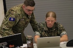 A U.S. Marine and member of the Virginia Defense Force simulate the process they would follow to respond to and mitigate a cyber attack Aug. 5, 2026, during Cyber Fortress 26 at the State Military Reservation in Virginia Beach, Virginia. Hosted by the Virginia Army National Guard’s 91st Cyber Brigade, Cyber Fortress is one of the nation's premier military exercises focused on a whole-of-government response to significant cyber threats impacting critical infrastructure and key resources, and the only Army National Guard cyberspace operations exercise that includes capability certification or re-certification. This year’s exercise scenario focused on hydroelectricity and brought together Active, Reserve, and National Guard components of the U.S. military and NATO partners, as well as local, state, and federal government agencies and civilian partners from private industry. (U.S. National Guard photo by A.J. Coyne)