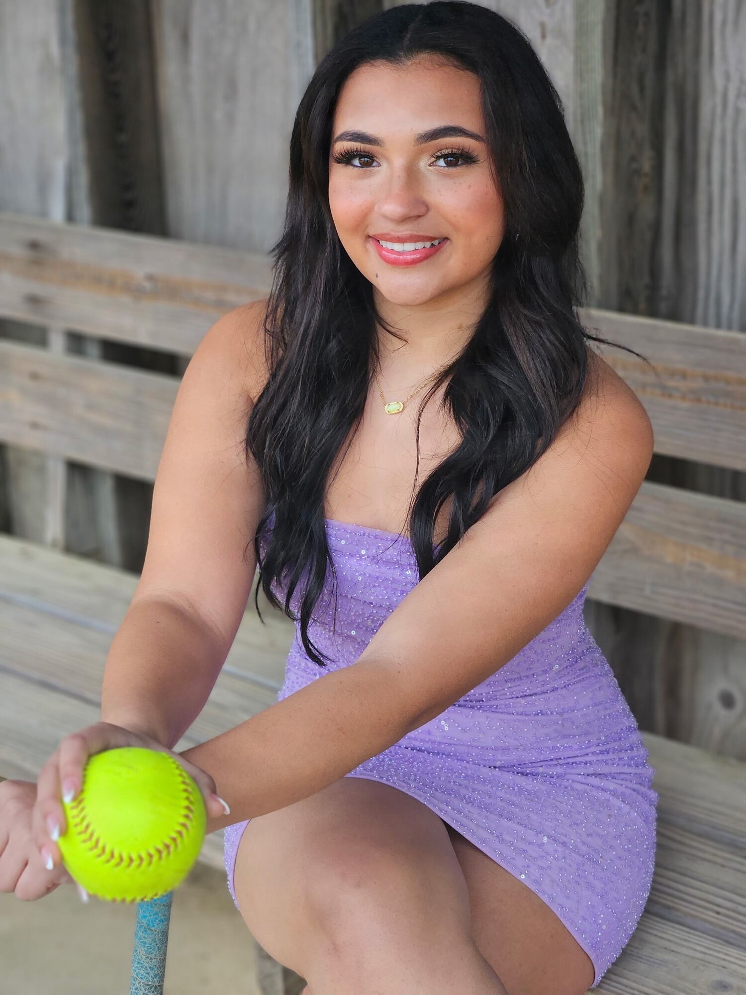 New York Air National Guard Master Sgt. Sara Luna’s daughter, Kristin Luna, poses with a softball in the varsity softball dugout at Center Moriches High School in Center Moriches, N.Y., March 4, 2025. The photo supported a feature highlighting her selection as a semifinalist for the 2026 Operation Homefront Military Child of the Year Award. (Courtesy Photo)