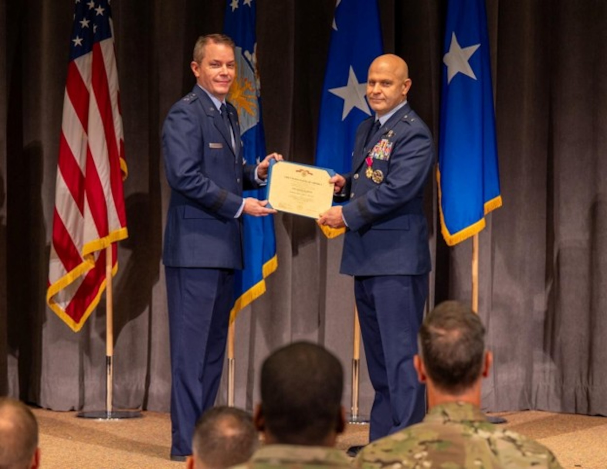 U.S. Air Force Maj. Gen. Jeffrey W. Nelson, Air Force Accessions Center commander, presents the Legion of Merit to Brig. Gen. Joseph Sheffield, Jeanne M. Holm Center outgoing commander, at Officer Training School, Maxwell Air Force Base, Aug 18, 2026. This change of command marks the transition of leadership for an organization responsible for Officer Training School, Air Force ROTC, Warrant Officer Training School, and Air Force Junior ROTC. (U.S. Air Force photo by Senior Airman Tanner Doerr)