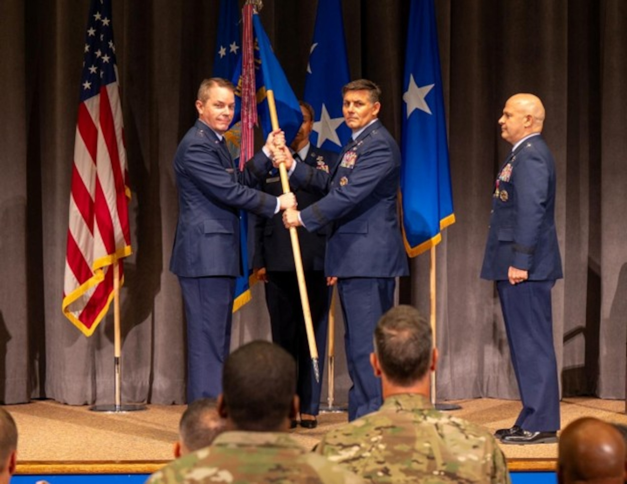 U.S. Air Force Brig. Gen. Christopher Lay, Jeanne M. Holm Center incoming commander, receives the Holm Center Guidon from Maj. Gen. Jeffrey W. Nelson, Air Force Accessions Center commander at Officer Training School, Maxwell Air Force Base, Aug. 18, 2026. The Holm Center is responsible for producing approximately 85% of officers entering the Department of the Air Force total force, making its mission critical to developing and preparing the next generation of Airmen and Guardians. (U.S. Air Force photo by Senior Airman Tanner Doerr)