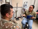 A hospital tech discusses tobacco cessation with a patient in a clinical setting.