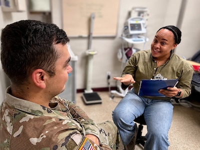 A hospital tech discusses tobacco cessation with a patient in a clinical setting.