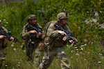 An Indiana National Guardsman assigned to the 1st Battalion, 151st Infantry Regiment, and Slovak Armed Forces soldiers run toward an objective during an assault at a Combat Readiness Exercise at Muscatatuck Training Center near Butlerville, Ind., July 26. The exercise validates the Indiana National Guard’s ability to rapidly deploy, integrate with joint and international partners, and fight in complex, large-scale combat operations. Photo by Staff Sgt. Hector Tinoco.