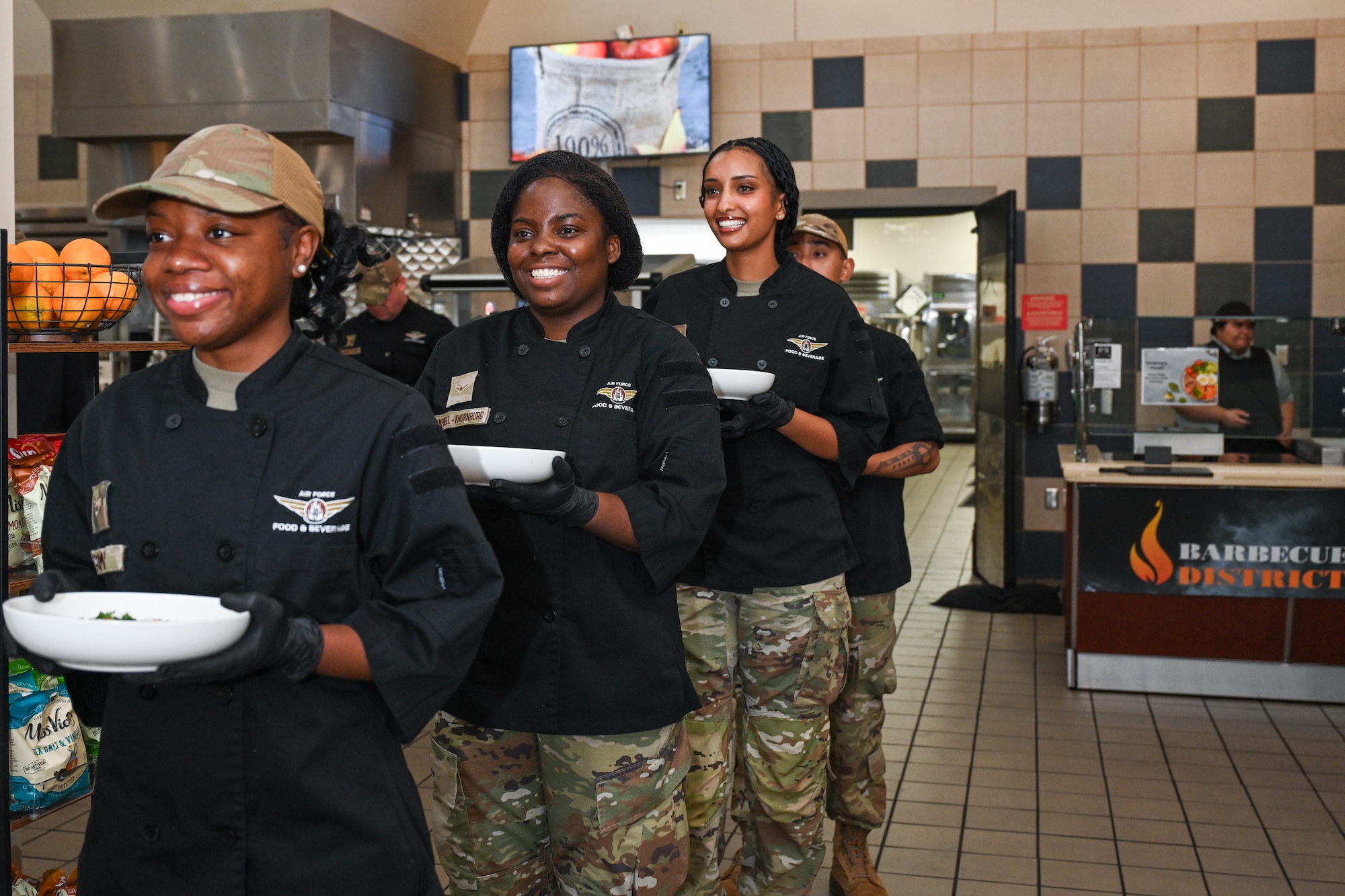 Airmen hold plates of food.