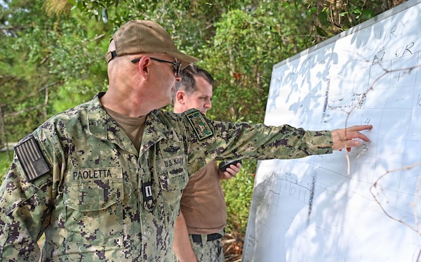 Lt. Jason Paoletta, assigned to Expeditionary Medical Facility 150 Mike, instructs patient administration movement to Hospital Corpsman 3rd Class Konstantin Lukianenko during an Expeditionary Medicine Sustainment Training exercise July 31. Lukianenko served as a recorder during the training during the two-day event.  (U.S. Navy photo by Julie M. Lucas)
