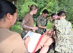 An assessment is performed while preparing to place a pelvic binder by Expeditionary Medical Facility 150 Mike Sailors during the Expeditionary Sustainment training exercise July 31. The exercise incorporated patient movement, patient tracking, triage, treatment, and surgical intervention. (U.S. Navy photo by Julie M. Lucas)