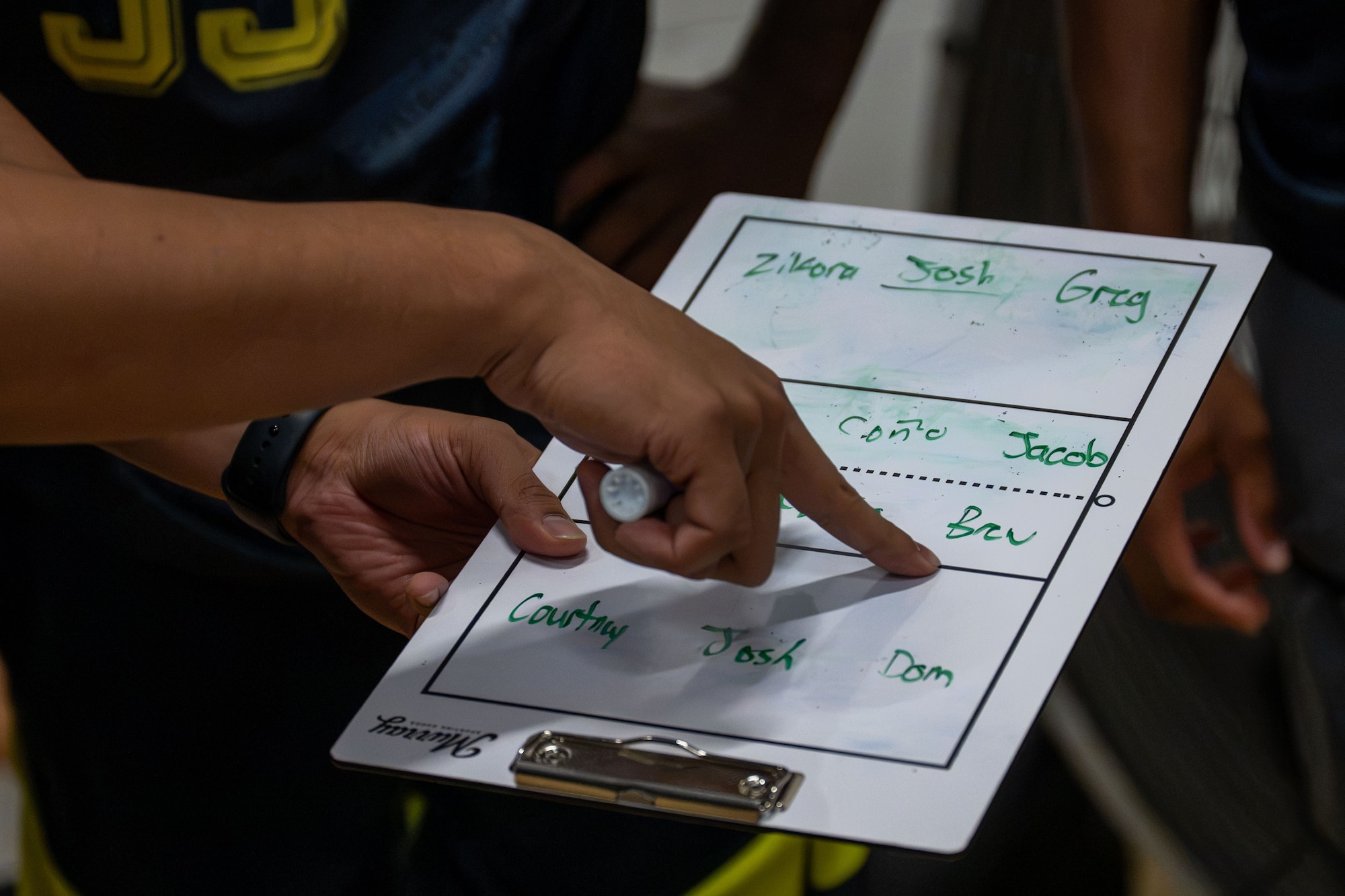 Hand points at a clip board.