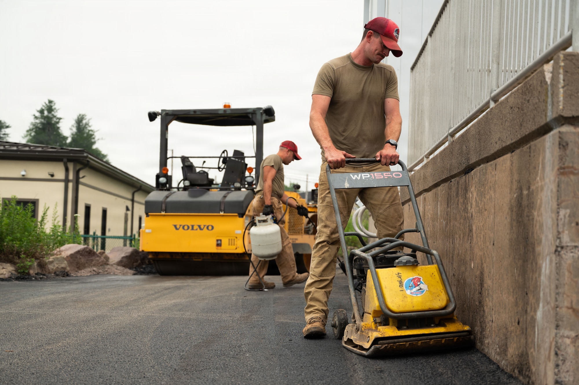 U.S. Air National Guard Master Sgt. Joseph Derbyshire, assigned to the 111th Attack Wing’s 201st RED HORSE Squadron, Detachment 1, operates a plate compactor during paving operations at Tobyhanna Army Depot, Pa., July 16, 2026. The project allowed Airmen to sharpen pavement construction skills through hands-on training while completing infrastructure improvements for the depot. (U.S. Air National Guard photo by Senior Airman Matthew Bergh)