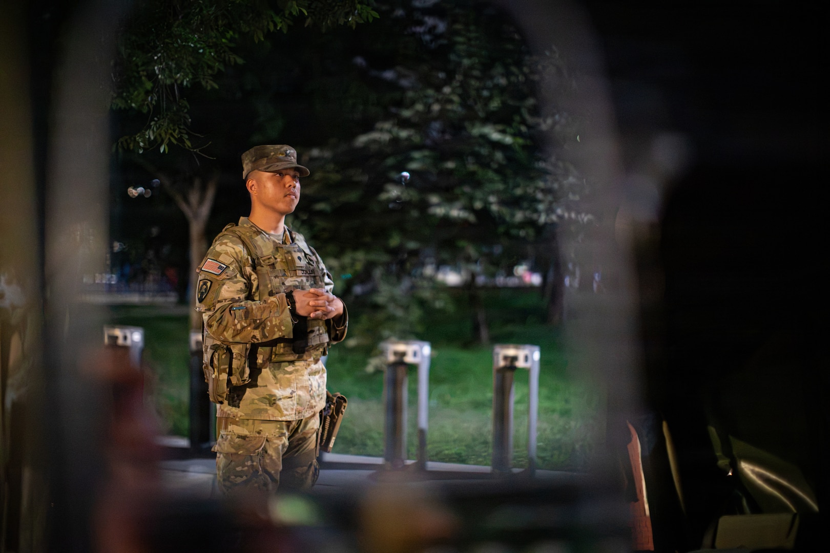 Seen through the reflection of a HUMVEE mirror, U.S Army Spc. Aaron Malado U.S. assigned to Joint Task Force-District of Columbia (JTF-DC) in support of the DC Safe and Beautiful mission, stands vigilant while on patrol near LeDroit Park in Washington, Aug 15, 2026. Malado was one of several service members who assisted in locating and returning a missing child to their guardian several days prior. About 4,500 National Guard members are supporting the mission, providing critical assistance to the Metropolitan Police Department to help ensure the safety of residents, commuters, and visitors throughout the District.