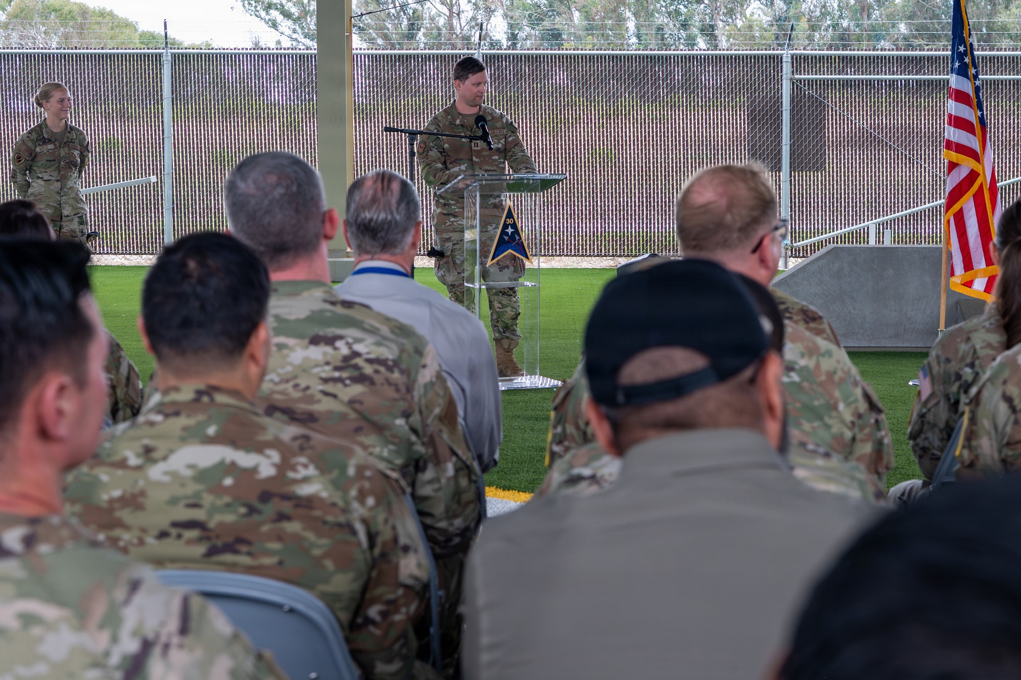 A person stands and speaks behind a podium