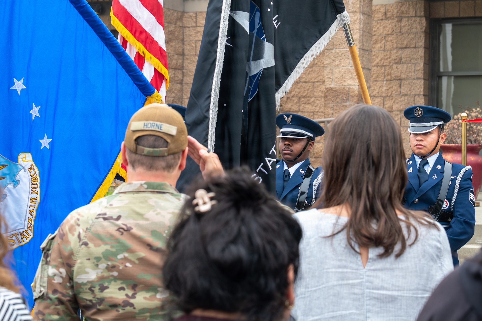 People stand and some salute