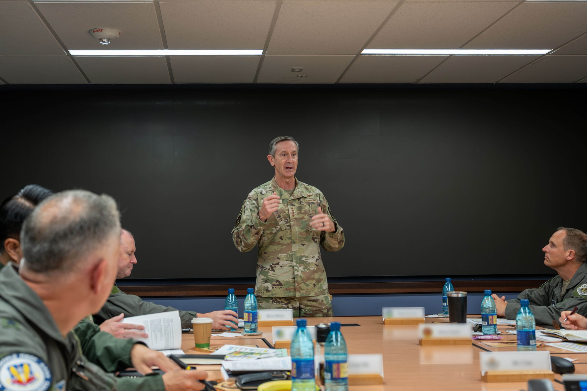 A military officer speaks at a table
