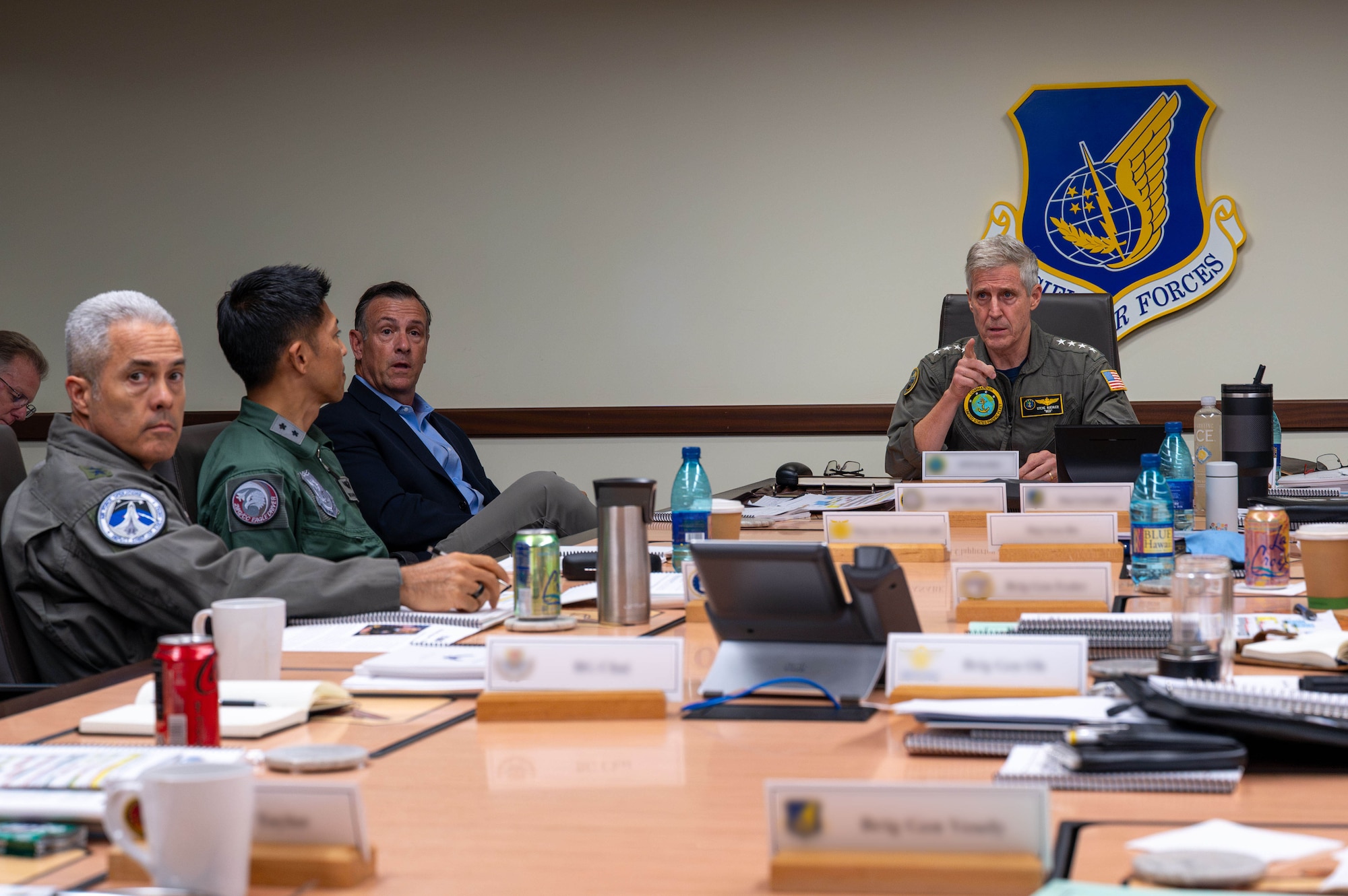 Military officers speak around a table