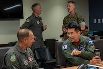 Two military officers speak to one another