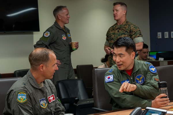 Two military officers speak to one another