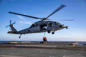 U.S. Navy Aviation Ordnancemen 3rd Class Kiomasa Kaminanga and U.S. Navy Aviation Ordnancemen 3rd Class Damien Heard, both assigned to Wasp-class amphibious assault ship USS Makin Island (LHD 8), conduct a vertical replenishment exercise with an MH-60S Sea Hawk, attached to Helicopter Sea Combat Squadron (HSC) 23, on the flight deck, August 18, 2026.