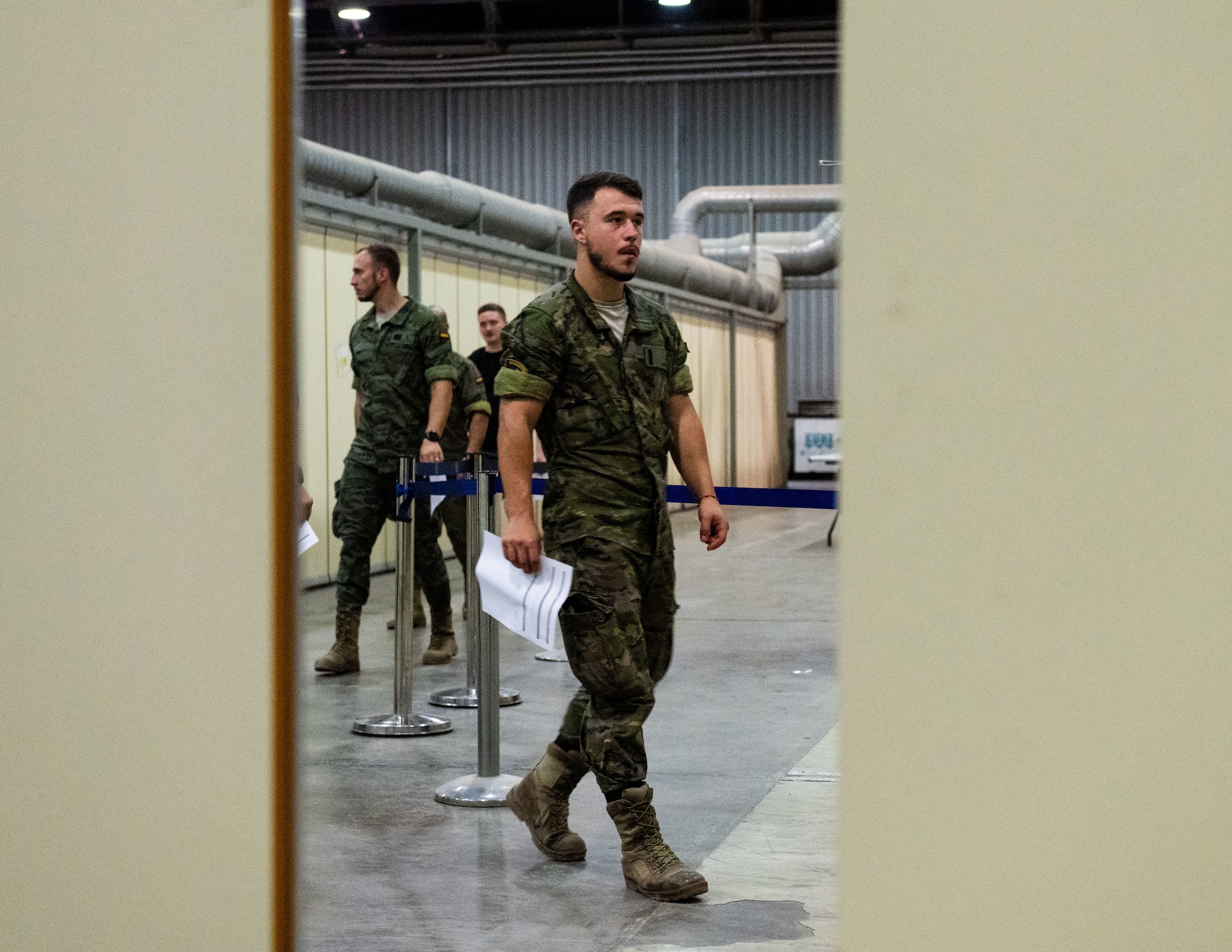 A Spanish soldier assigned to the Spanish Patriot Unit moves through a designated processing area.