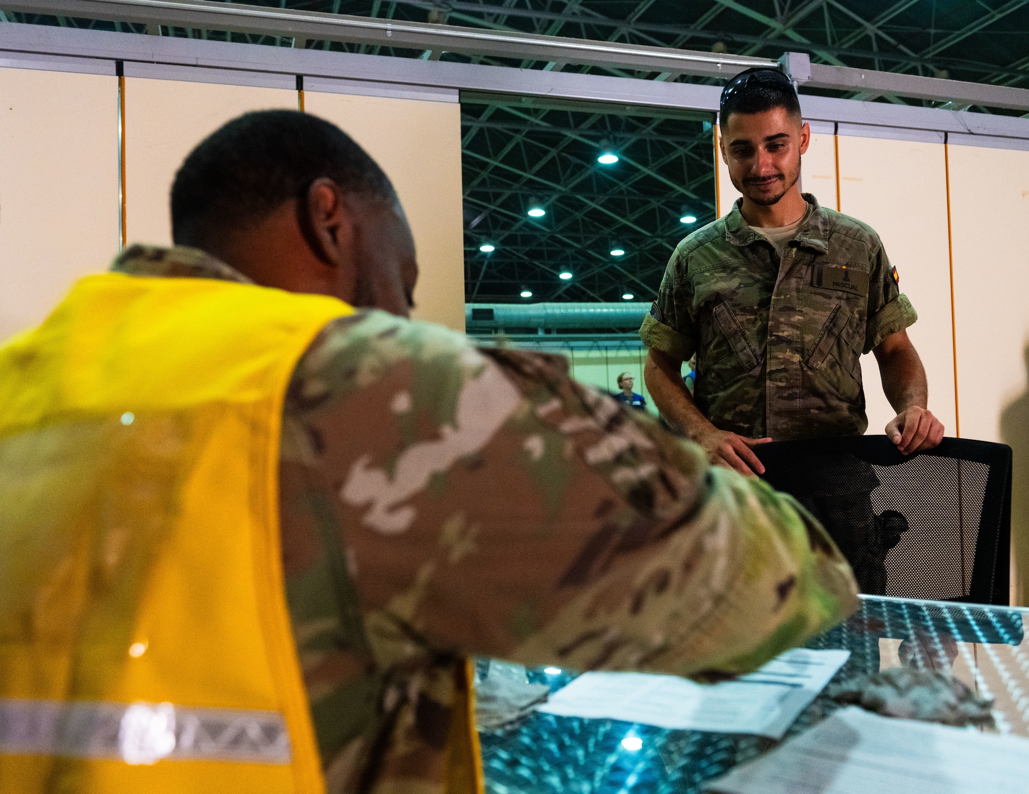 A Spanish solider assigned to the Spanish Patriot Unit, right, checks in with a U.S. Airman assigned to the 39th Medical Group.