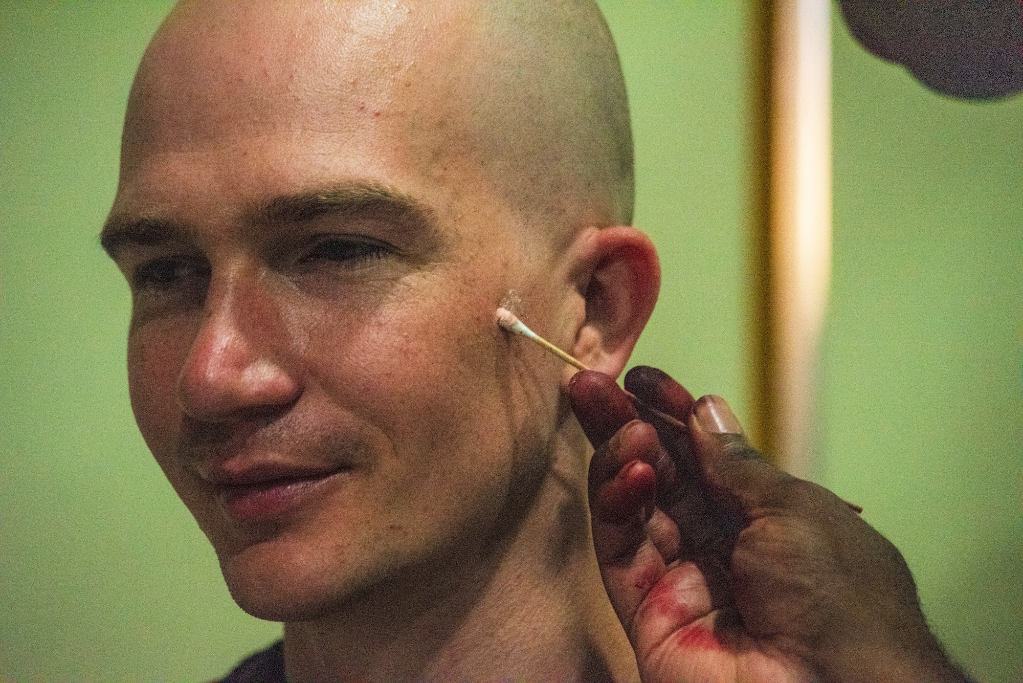 A U.S. Airman assigned to the 39th Medical Group applies moulage to an exercise participant.