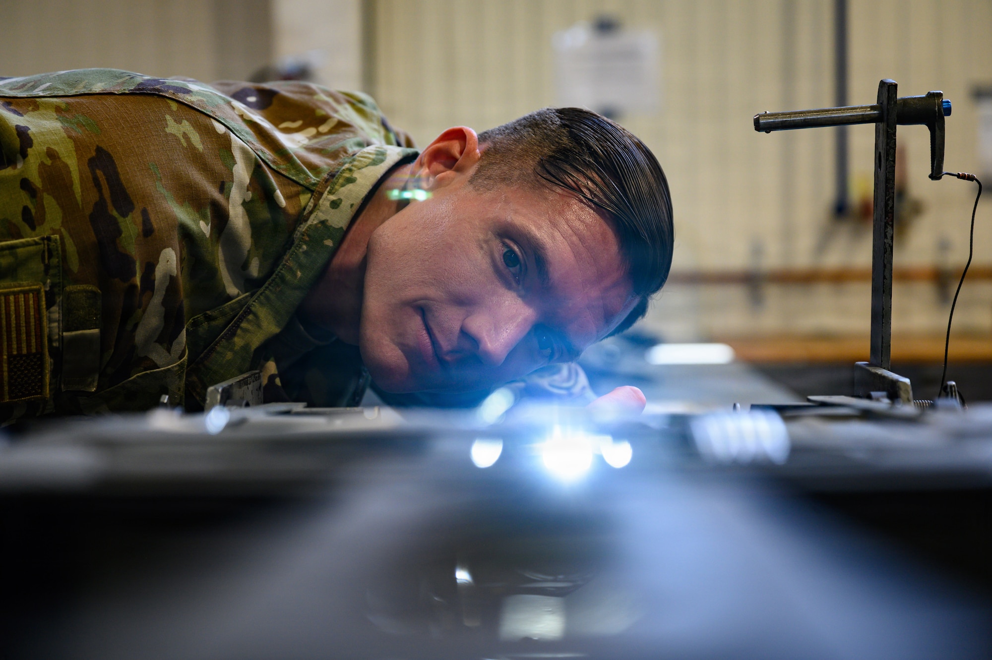 A person uses a light to inspect an ejection seat.