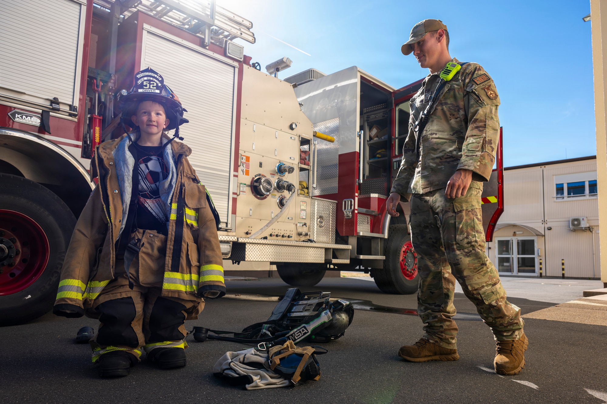 A child wears firefighting gear.
