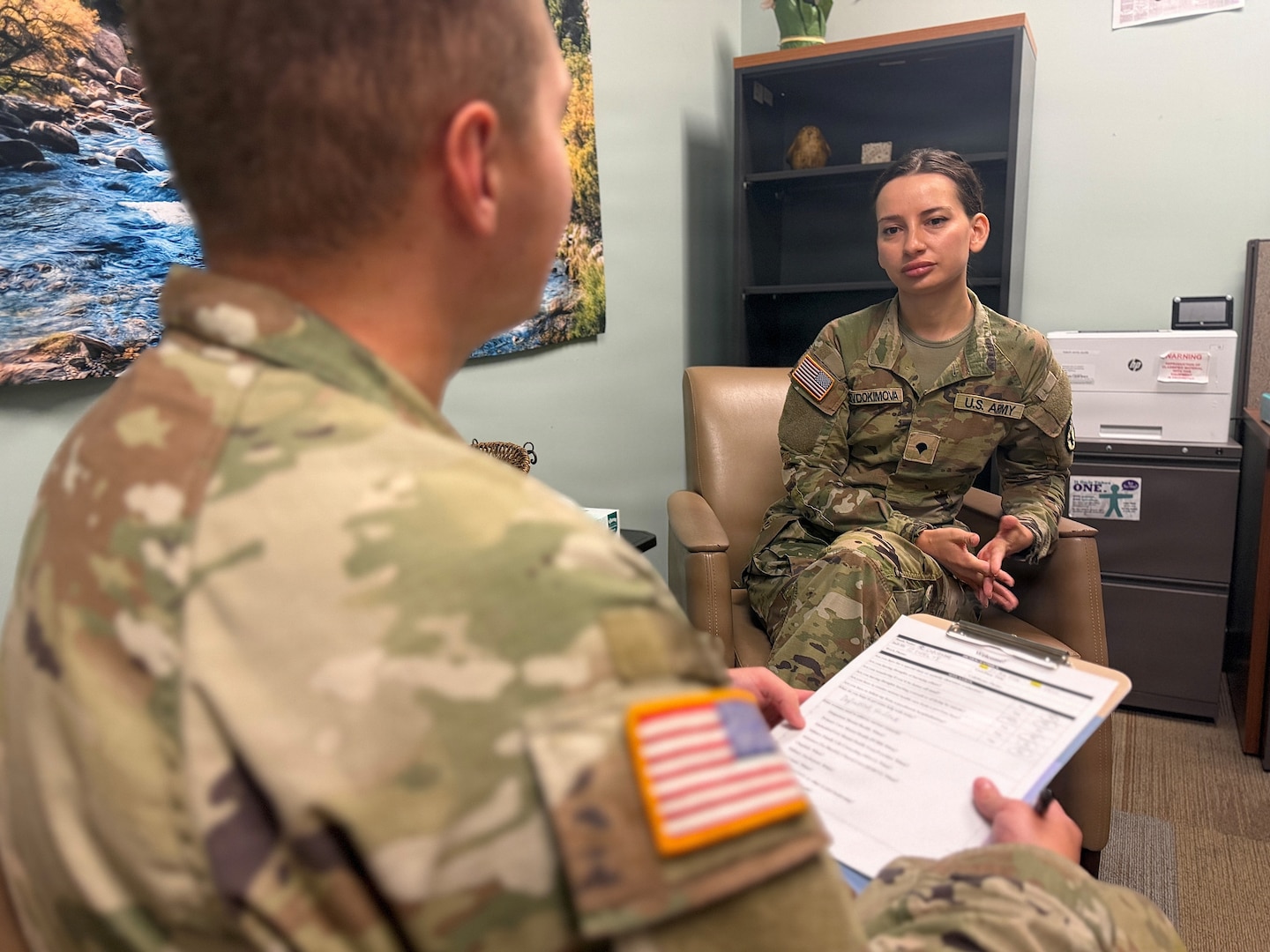 A mental health provider talks with a patient in a clinical office setting.