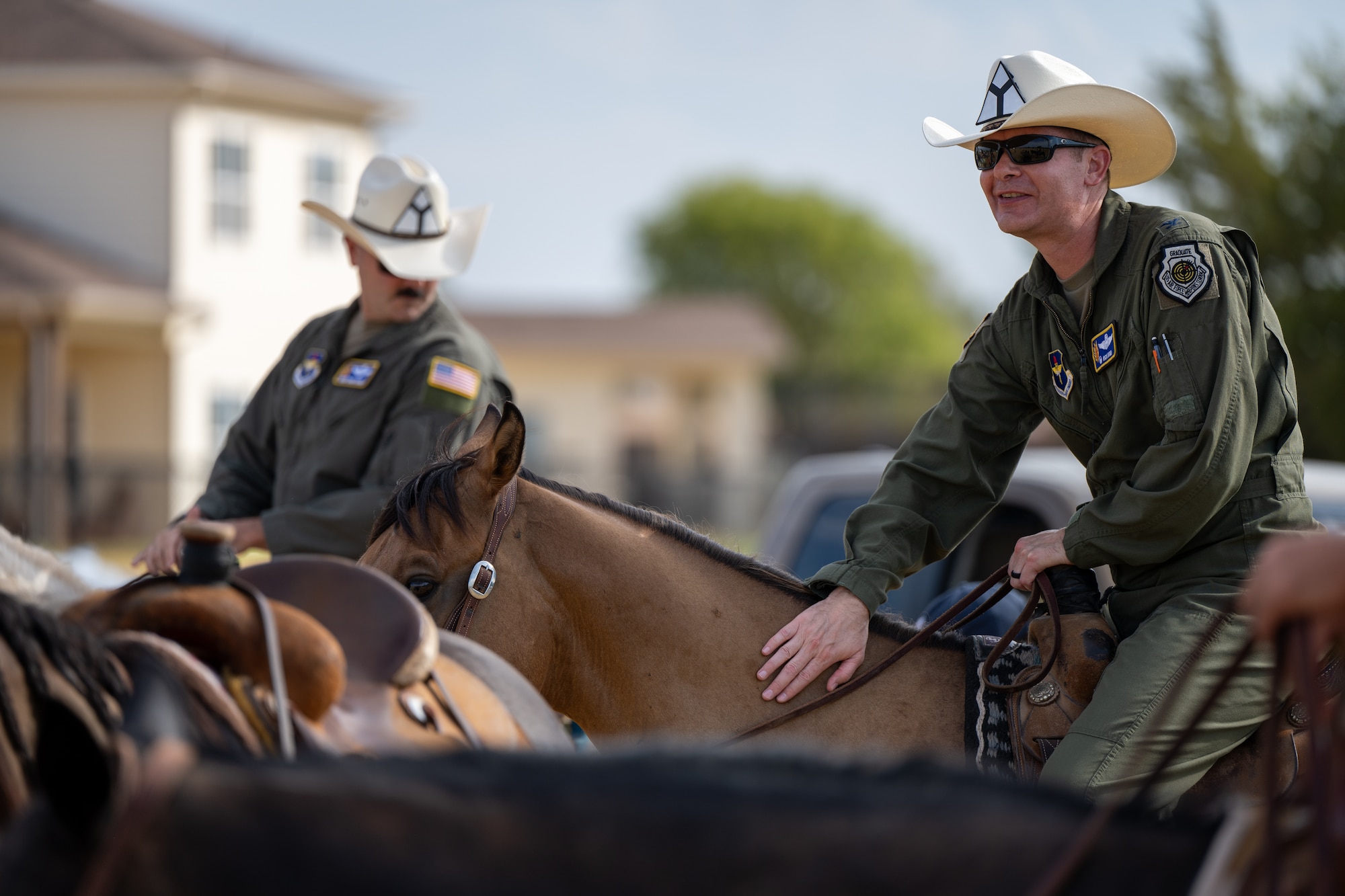 Col. Richard Kind, 97th Air Mobility Wing commander, right, and Chief Master Sgt. Jonny Adams, 97th AMW command chief, sit on horseback during the annual Cattle Drive at Altus Air Force Base, Oklahoma, Aug. 20, 2026. The event, hosted in partnership with the local community, celebrates the shared history and longstanding relationship between the city of Altus and Altus AFB. (U.S. Air Force photo by Airman 1st Class Nathan Langston)