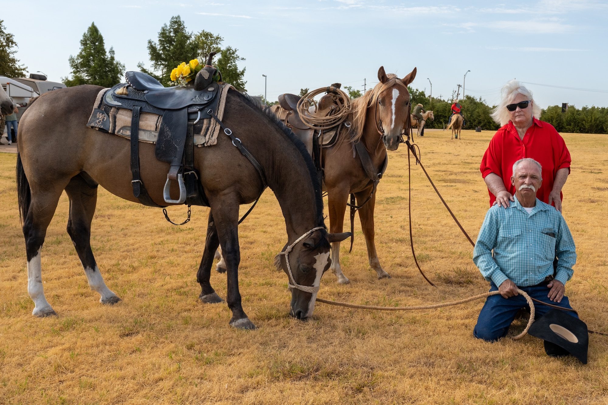 Judith Watkins, wife of the late Gary ‘Bull’ Watkins, leans on Randy Braker, a family friend, during the 28th Annual Cattle Drive at Altus Air Force Base, Oklahoma, Aug. 20, 2026. Braker rode next to Bull Watkins’ horse with yellow roses attached to the saddle to honor the rancher who long helped run the Cattle Drive at Altus AFB. (U.S. Air Force photo by Senior Airman Kari Degraffenreed)