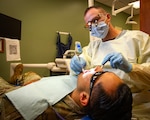 FORT RILEY, Kan. — Dylan Banks, a U.S. Air Force veteran and fourth-year dental student at the University of Missouri-Kansas City School of Dentistry, performs a dental examination on a Soldier at Fort Riley Aug. 17, 2026. Banks is completing a clinical externship at the installation, gaining hands-on experience in Army dentistry. The partnership allows civilian students to learn how Army dental teams prioritize deployment readiness and provide high-quality, mission-driven care.