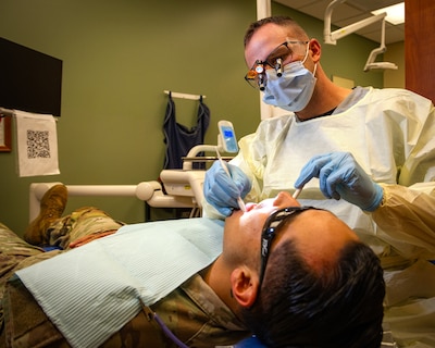 FORT RILEY, Kan. — Dylan Banks, a U.S. Air Force veteran and fourth-year dental student at the University of Missouri-Kansas City School of Dentistry, performs a dental examination on a Soldier at Fort Riley Aug. 17, 2026. Banks is completing a clinical externship at the installation, gaining hands-on experience in Army dentistry. The partnership allows civilian students to learn how Army dental teams prioritize deployment readiness and provide high-quality, mission-driven care.
