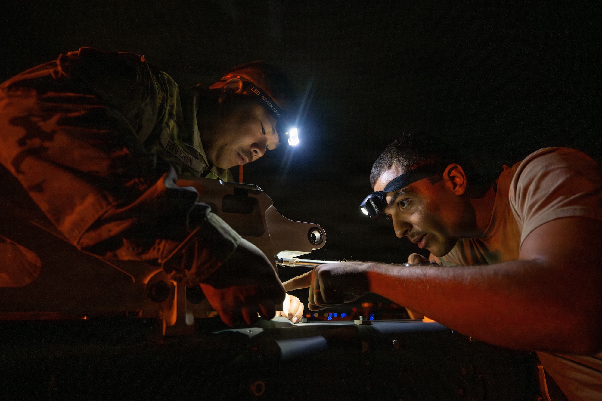 U.S. Air Force Staff Sgt. Daniel Rivera, 325th Aircraft Maintenance Squadron weapons team chief, and Airman 1st Class Lance Toland, 325th AMXS weapons load crew member, place an adaptor onto a munition during Weapons System Evaluation Program-Combat Hammer 26.07 at Hill Air Force Base, Utah, Aug. 12, 2026.