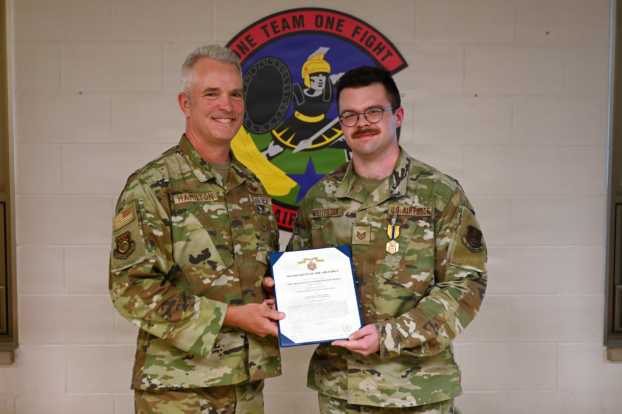 U.S. Air Force Brig. Gen. Darren Hamilton, Ohio National Guard chief of staff, presents the Air Force Commendation Medal with "C" Service to Tech. Sgt. Anthony Breitfelder, an air battle manager asigned to the 123rd Air Control Squadron, during a ceremony Aug. 1, 2026 at Blue Ash Air National Guard Station. The combat "C" device recognizes meritorius service or acheivement performed while the recipient was personally exposed to hostile action in combat. (U.S. Air National Guard photo by Shane Hughes)