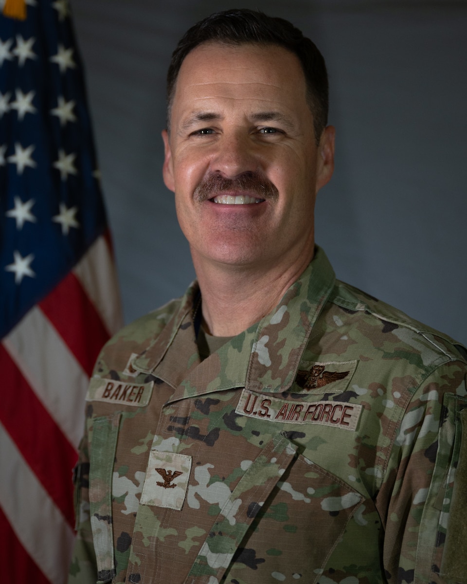 Official Air Force photo: grey background, three point lighting, and American flag on stand.