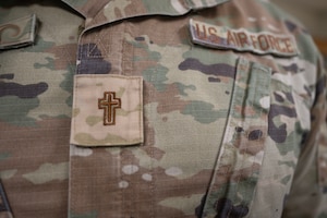 A chaplain assigned to the 1st Special Operations Wing wears a religious insignia on his chest.